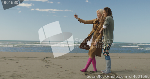 Image of Girls having time and taking selfie on a beach