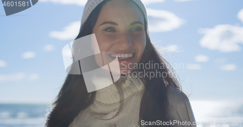 Image of Girl In Autumn Clothes Smiling on beach