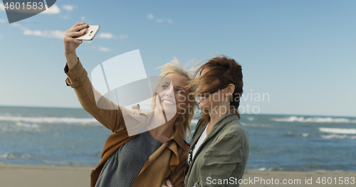 Image of Girls having time and taking selfie on a beach