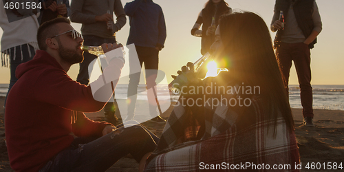 Image of Friends having fun at beach on autumn day