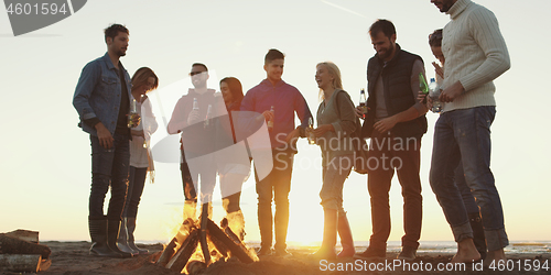 Image of Friends having fun at beach on autumn day