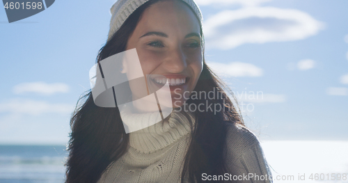 Image of Girl In Autumn Clothes Smiling on beach