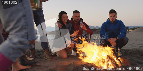 Image of Friends having fun at beach on autumn day