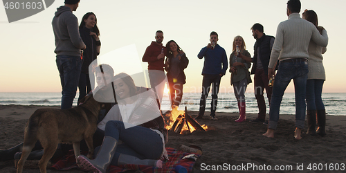 Image of Friends having fun at beach on autumn day