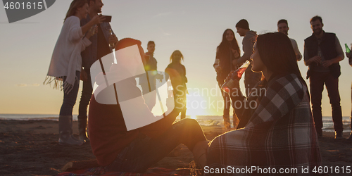 Image of Friends having fun at beach on autumn day