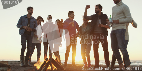 Image of Friends having fun at beach on autumn day