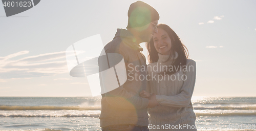 Image of Couple having fun on beautiful autumn day at beach