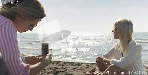 Image of Two girl friends having fun photographing each other on vecation