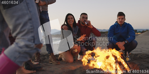 Image of Friends having fun at beach on autumn day