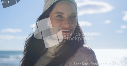 Image of Girl In Autumn Clothes Smiling on beach