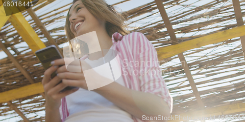 Image of Smartphone Woman Texting On Cell Phone At Beach