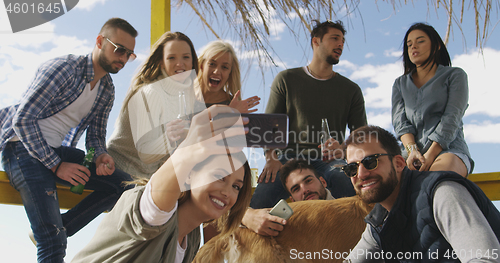 Image of Group of friends having fun on autumn day at beach