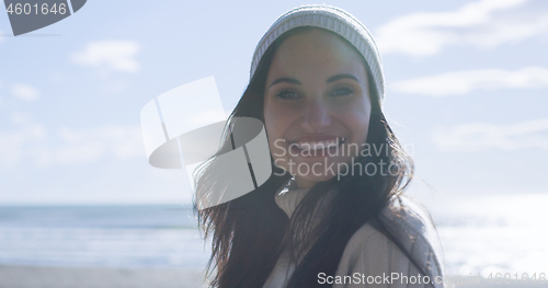 Image of Girl In Autumn Clothes Smiling on beach