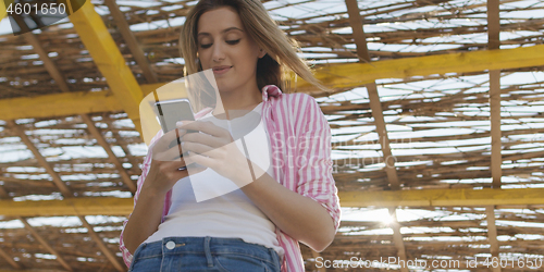 Image of Smartphone Woman Texting On Cell Phone At Beach