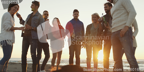 Image of Friends having fun at beach on autumn day