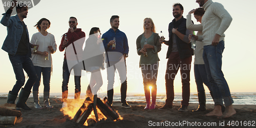 Image of Friends having fun at beach on autumn day