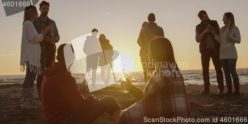 Image of Friends having fun at beach on autumn day