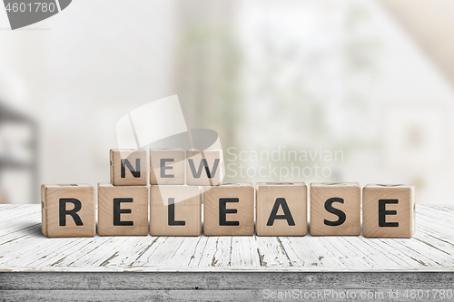 Image of New release sign on a wooden table in a bright room