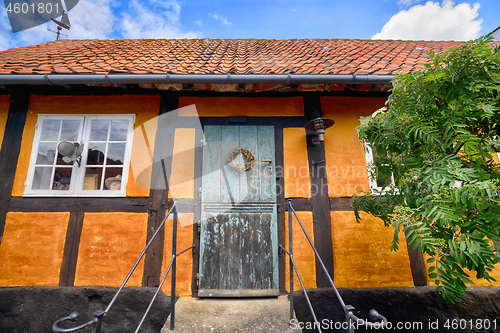 Image of Entrance to an old orange house under a blue sky