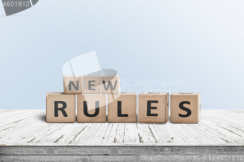 Image of New rules sign made of wood on a desk