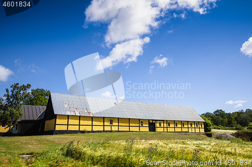 Image of Yellow barn on a green meadow