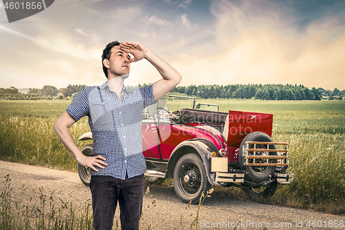 Image of Car out of fuel in a rural countryside with a male