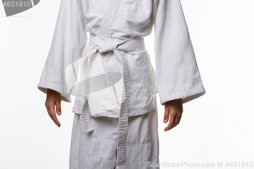 Image of Stages of correct tying of the belt by a teenager on a sports kimono, step ten is the final step