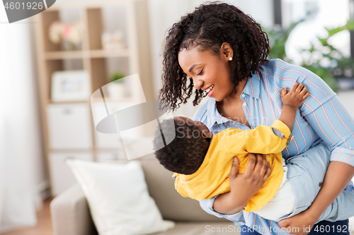 Image of happy african american mother with baby at home