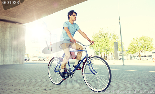 Image of young hipster man riding fixed gear bike