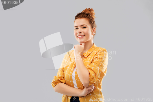 Image of smiling red haired teenage girl in checkered shirt