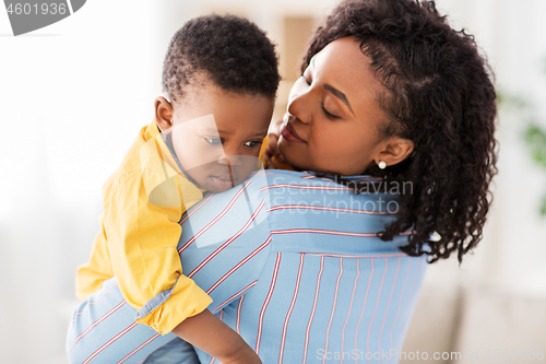 Image of african american mother with sad baby at home