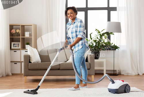 Image of woman or housewife with vacuum cleaner at home