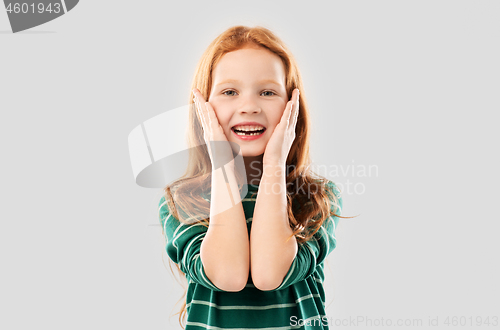 Image of smiling red haired girl in striped shirt