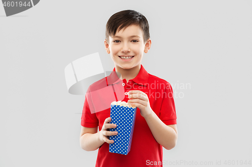 Image of smiling boy in red t-shirt eating popcorn