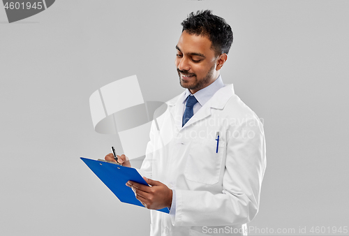 Image of smiling indian doctor or scientist with clipboard