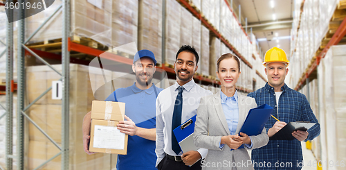 Image of group of business people and warehouse workers