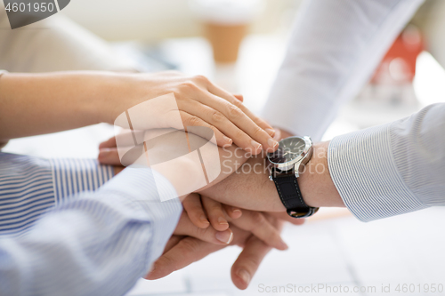 Image of close up of business team stacking hands