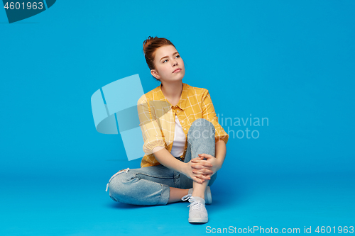 Image of red haired teenage girl in shirt and torn jeans