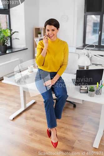 Image of happy woman and calling on smartphone at office