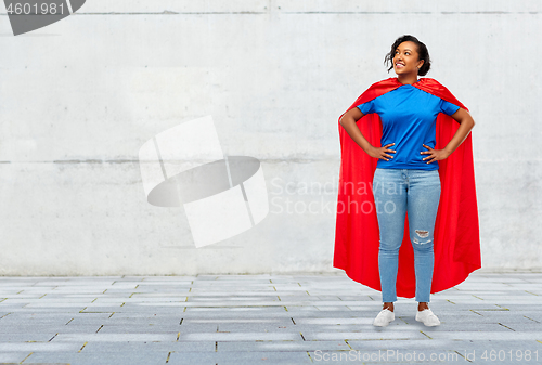 Image of happy african american woman in superhero red cape