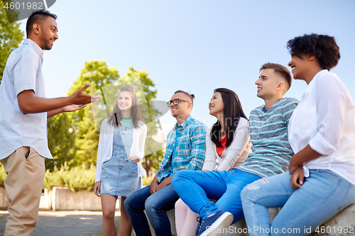 Image of happy international friends talking in city