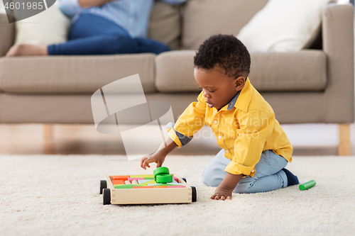 Image of african american baby boy playing with toy blocks