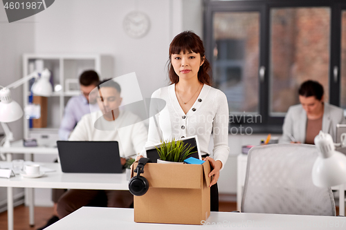 Image of female office worker with box of personal stuff