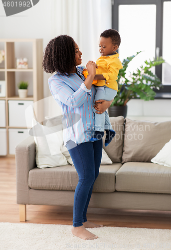 Image of happy african american mother with baby at home