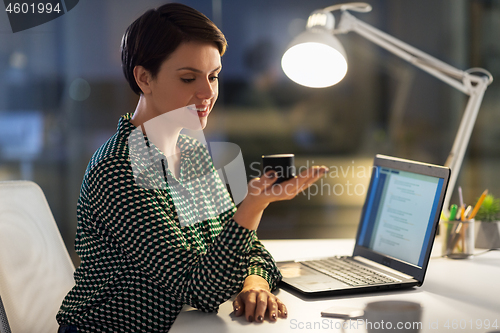 Image of businesswoman using smart speaker at night office