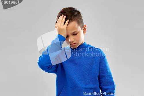 Image of sick boy in slue hoodie suffering from headache