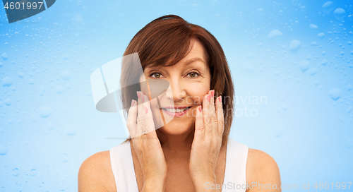 Image of portrait of smiling senior woman touching her face