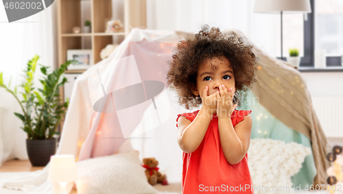 Image of confused african american girl covering mouth