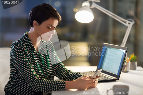 Image of smiling businesswoman using smartphone at office