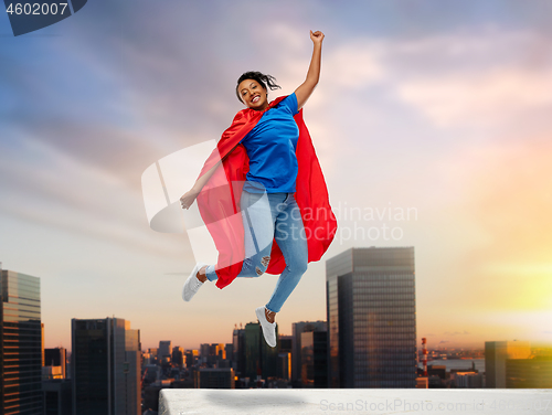 Image of happy african american woman in superhero red cape